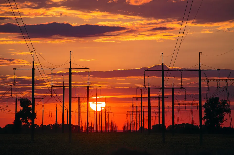 Sunset above high voltage power lines and electricity pylons.