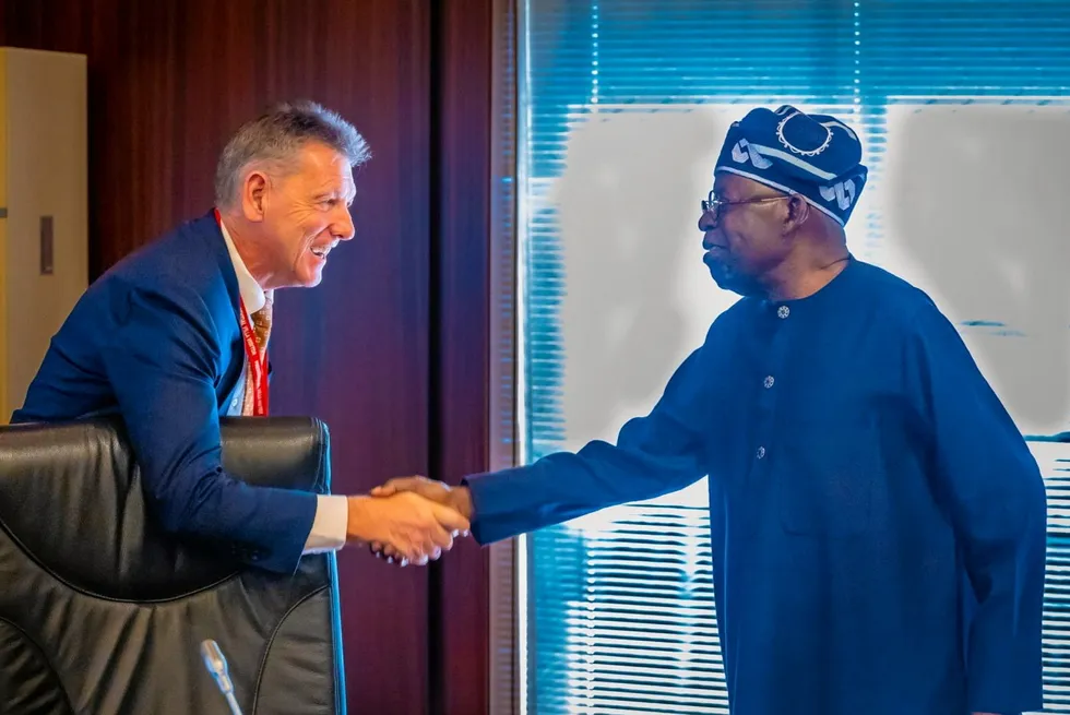 Nigeria's President Bola Tinubu (right) shakes hands with ExxonMobil's upstream head Liam Mallon.