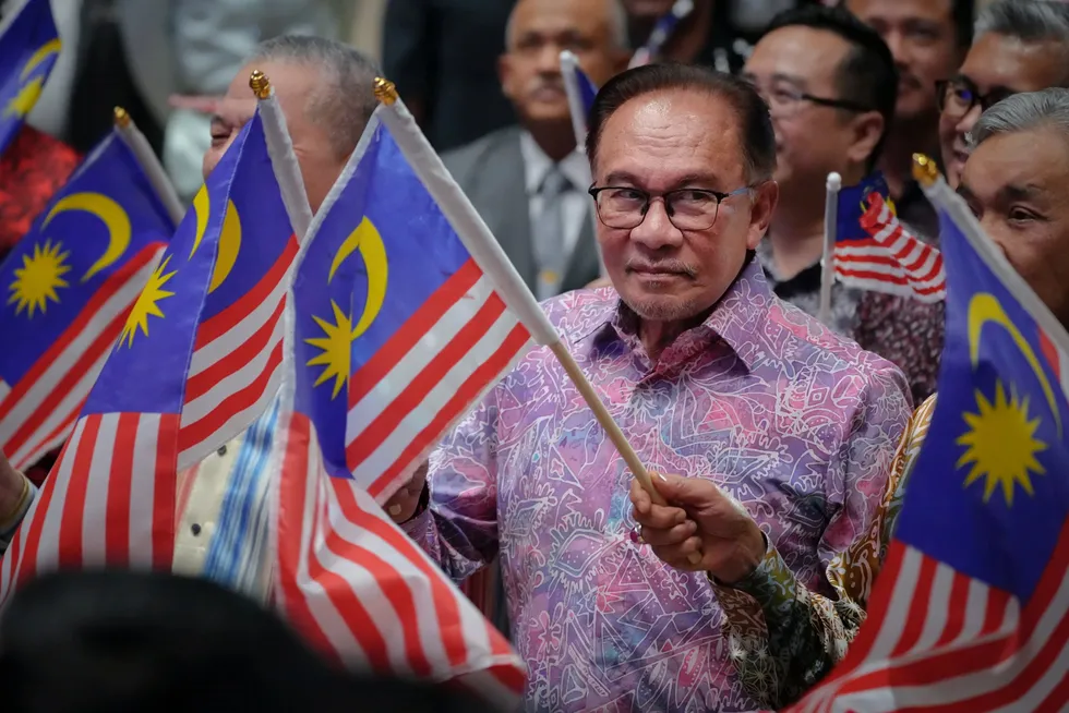 Malaysia's Prime Minister, Anwar Ibrahim, waves the national flag.