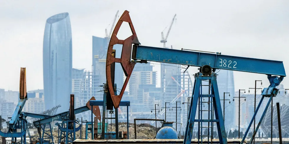 An oil field withe the buildings of Baku behind it.