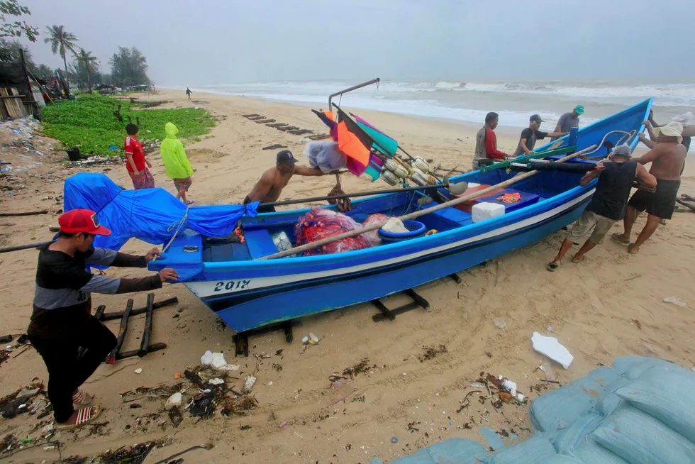 Pushing ahead: men move a fishing boat in Songkhla, Thailand