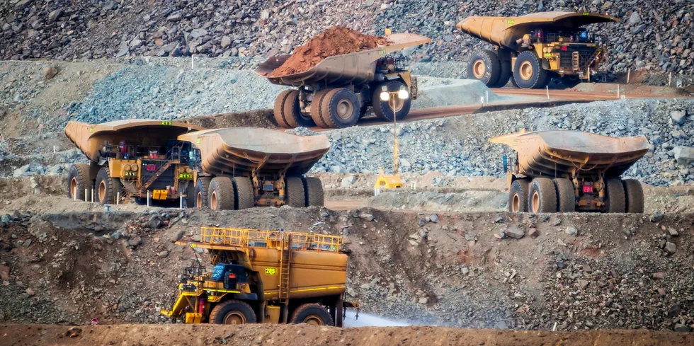 Six trucks in a busy modern gold mine in Western Australia.