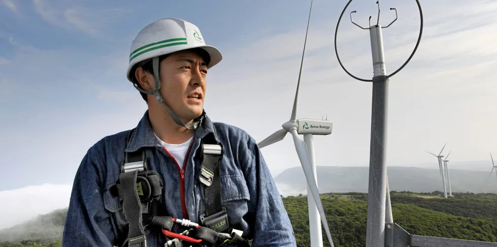 A wind turbine technician atop a turbine