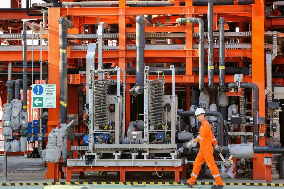A worker walks past infrastructure on the D-Island which is the main oil and gas processing hub at the Kashagan oi field in the Caspian sea in western Kazakhstan.