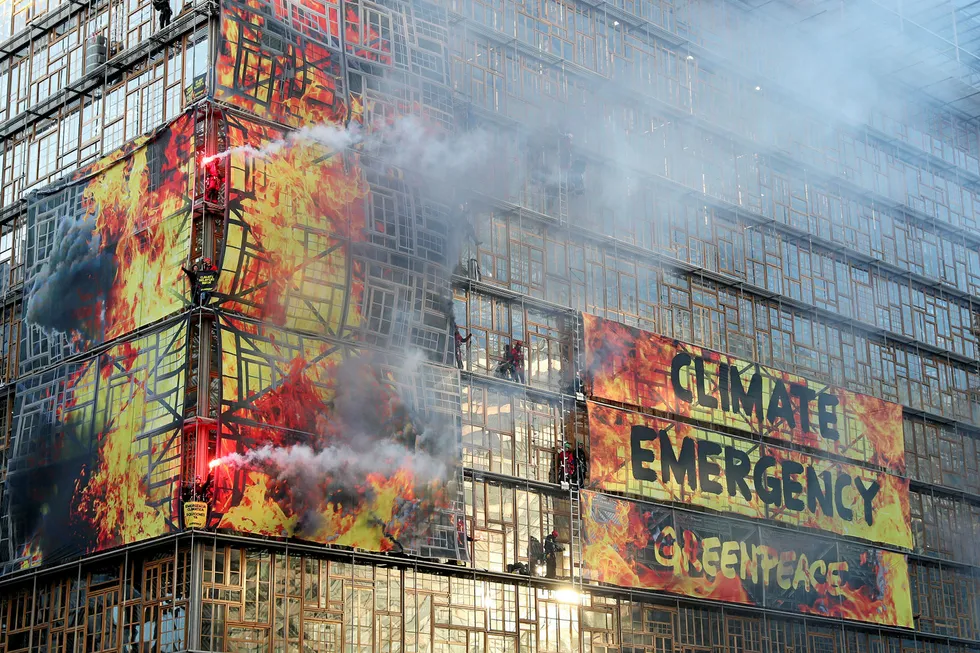 Climate protest: Climate change activists from Greenpeace light flares outside the EU Council headquarters, ahead of an EU leaders summit in Brussels, Belgium on 12 December.