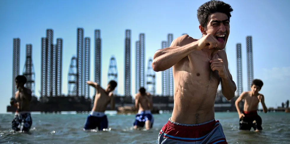 Teenagers from a boxing school take part in a training session in the Caspian Sea near Soviet oil rigs in Baku, Azerbaijan