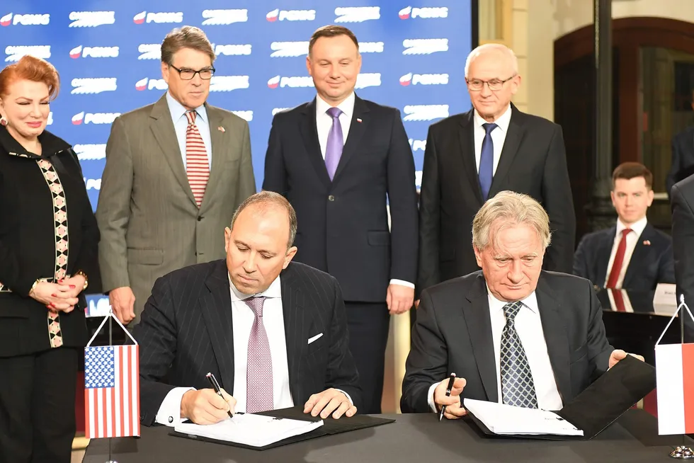 In this file photo from 8 November 2018 in Warsaw, Cheniere executive Anatol Feygin (left) and PGNiG chief executive Piotr Wozniak (right) sign a 24-year deal to deliver liquefied natural gas to Poland as (standing left to right) US ambassador to Poland Georgette Mosbacher, US Energy Secretary Rick Perry, Polish President Andrzej Duda and Poland Energy Minister Krzysztof Tchorzewski look on.