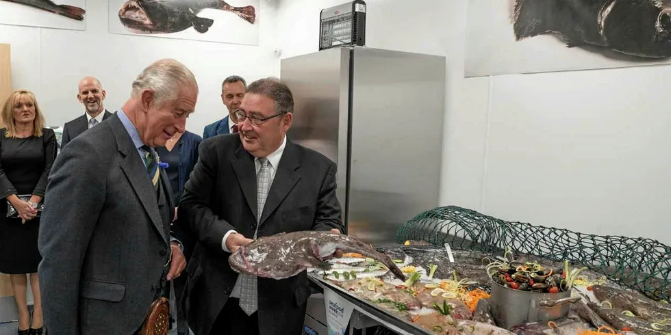 Prince Charles eyes up a monkfish at the official opening of Peterhead fish market.
