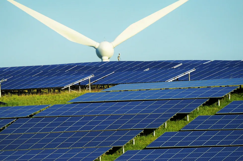 Large solar system with a wind turbine looming.