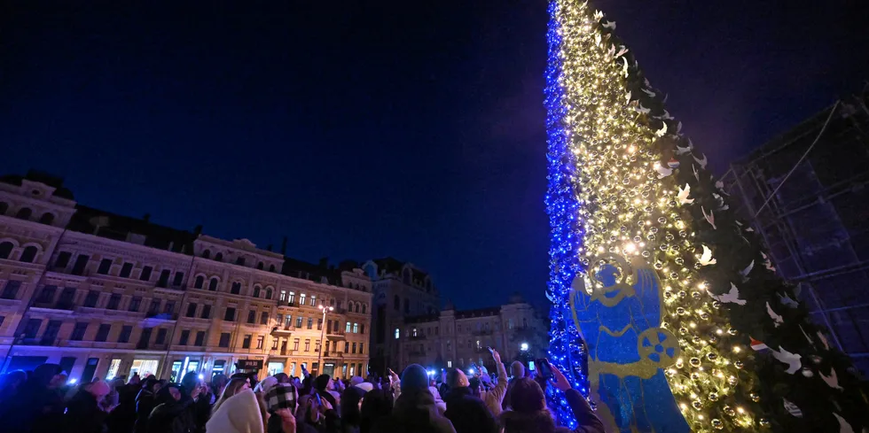People take selfie photographs during the unveiling ceremony of Kyiv's main Christmas tree on St. Sophia Square in the Ukrainian capital of Kyiv, on December 19, 2022.