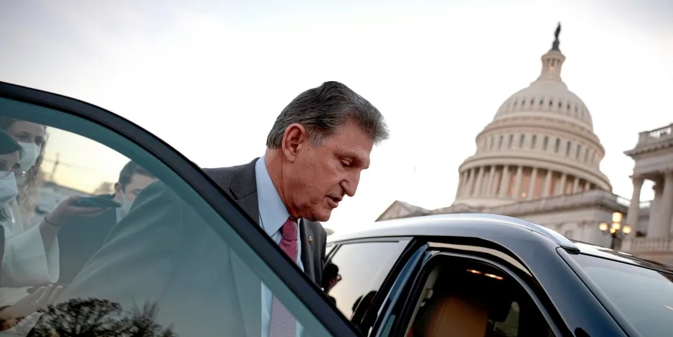 Sen. Joe Manchin (D-WV) is followed to his car by reporters.