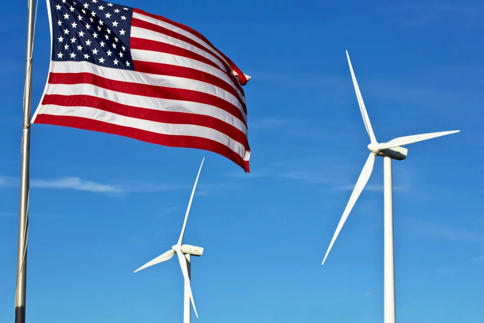 An American flag with two wind turbines