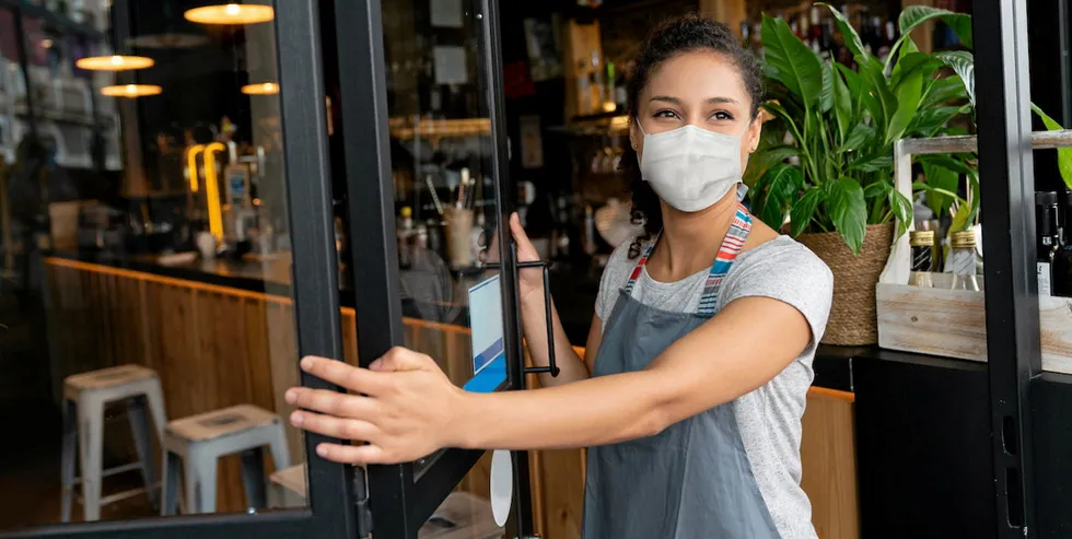 COME ON IN: A waitress opens doors for restaurant customers as COVID-19 lockdown restrictions relax. The uplift in foodservice business is driving much higher salmon prices in the US.