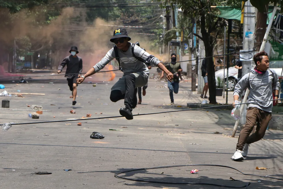 Heavy toll: anti-coup protesters run to avoid military forces during a demonstration in Yangon, Myanmar on 31 March
