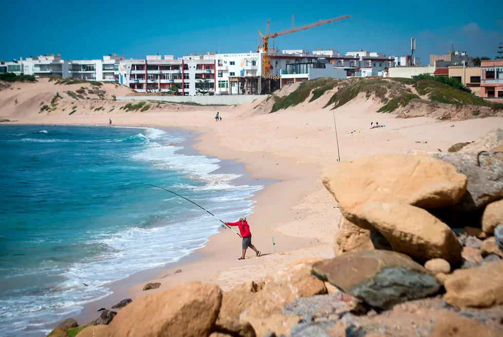 Casting out: a Moroccan man fishes on a beach in the city of Mohammedia