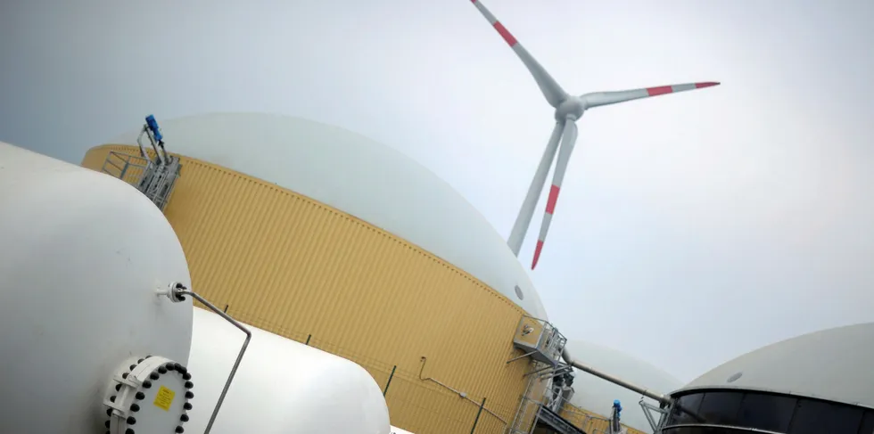 The hydrogen storage (L), the biogas storage (R) and a wind turbine (back) are seen at a hybrid power plant in Prenzlau, eastern Germany.