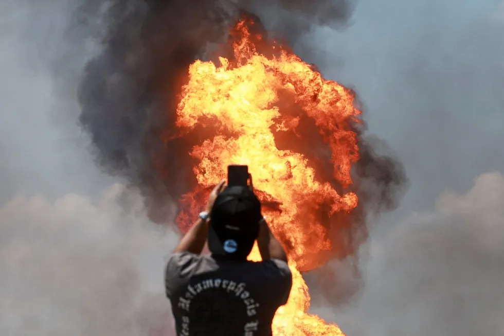 An onlooker takes a picture of the fire after a gas pipeline operated by Malaysia's state energy company Petronas caught fire, in Puchong, Malaysia, on 1 April 2025.