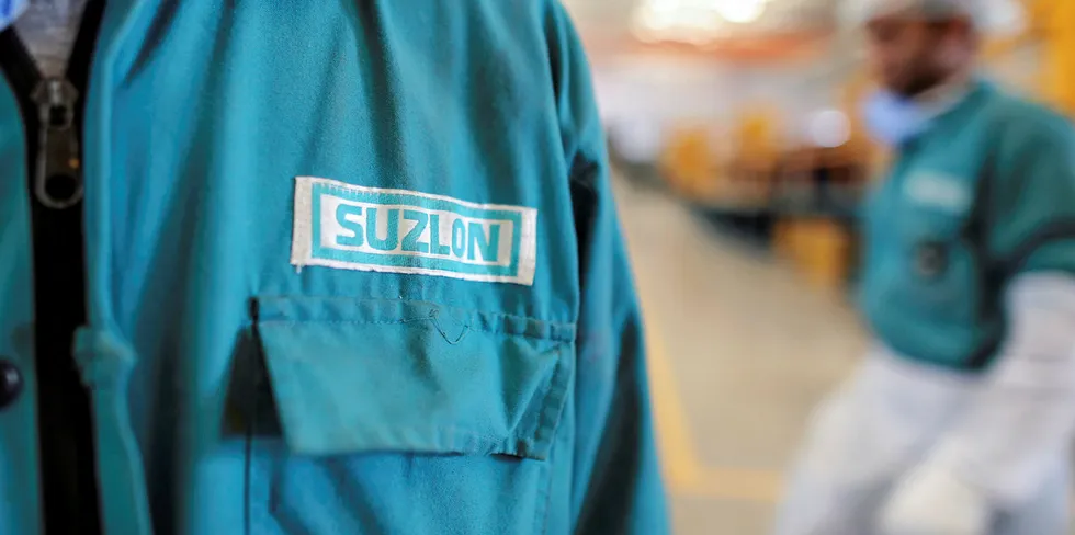 The Suzlon Energy Ltd. logo is displayed on an employee's uniform at the company's rotor blade manufacturing plant in Bhuj, India.