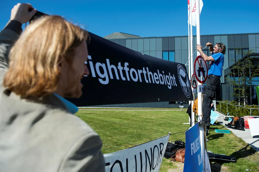 Protests: The Wilderness Society's Peter Owen (left) and Greenpeace activist Ulvar Arnkværn hang up a banner outside Equinor's AGM