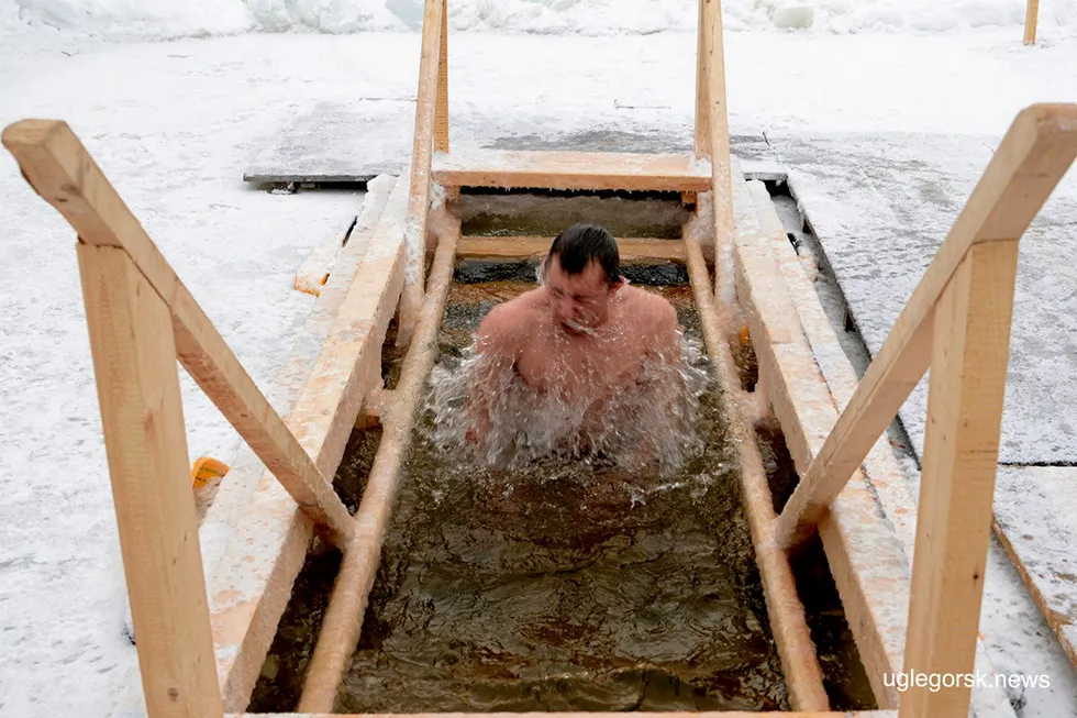 Defying obstacles: a pilgrim takes a dip in an ice hole on the Nadezhdinka river in Russia's Sakhalin Island