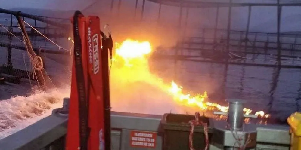A Huon salmon farm cage on fire in the early hours of the morning.