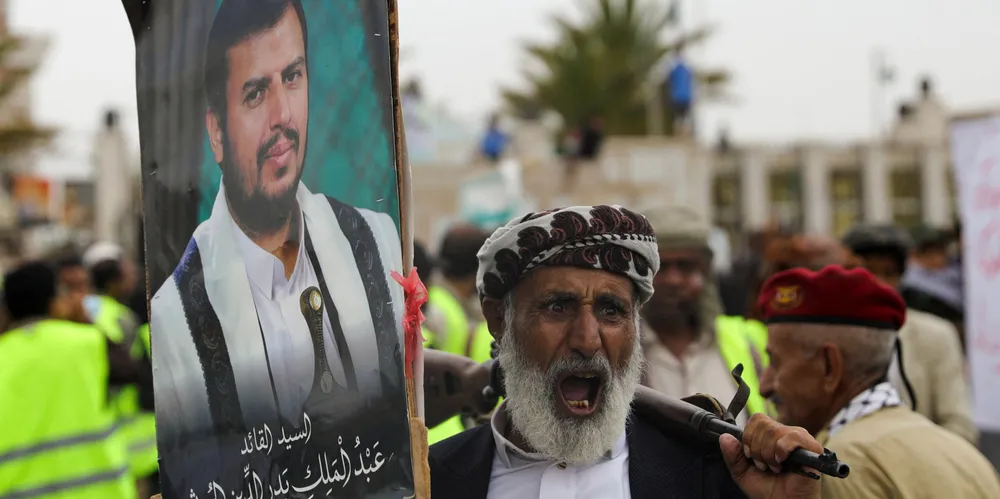 A protester holding a poster of Houthi leader Abdul-Malik al-Houthi.