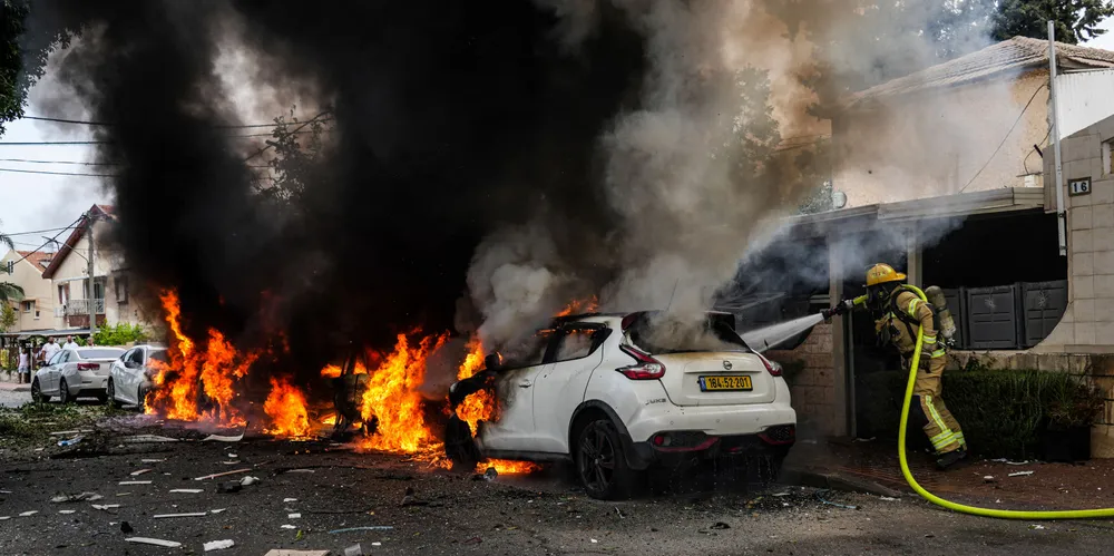 Israeli firefighters extinguish fire caused in Ashkelon by a rocket fired from the Gaza Strip.