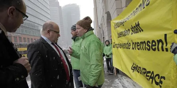 Peter Altmaier is greeted by campaigners ahead of talks with the states