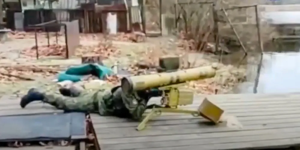 A soldier believed to be in Kherson, Ukraine, takes aim at commercial ships on the other side of the Dnipro River.
