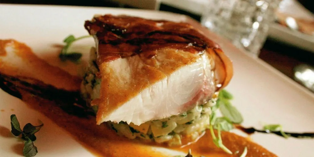 Prosciutto-wrapped Kona kanpachi with grilled corn risotto and roasted pepper gazpacho.