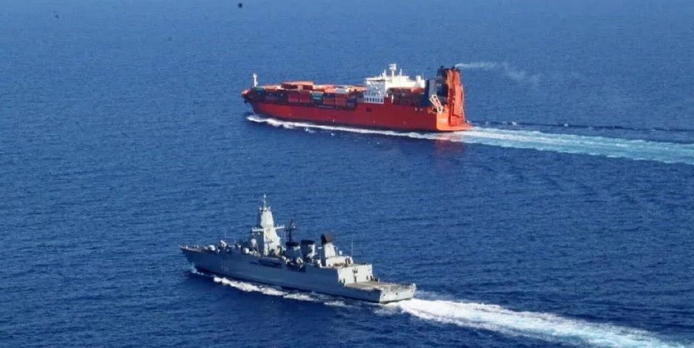 An EUNAVFOR warship provides close protection to a cargo vessel in the Red Sea.