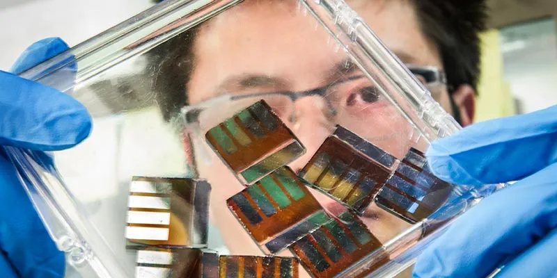 NREL researcher Mengjin Yang examines hybrid perovskite solar cells in his lab