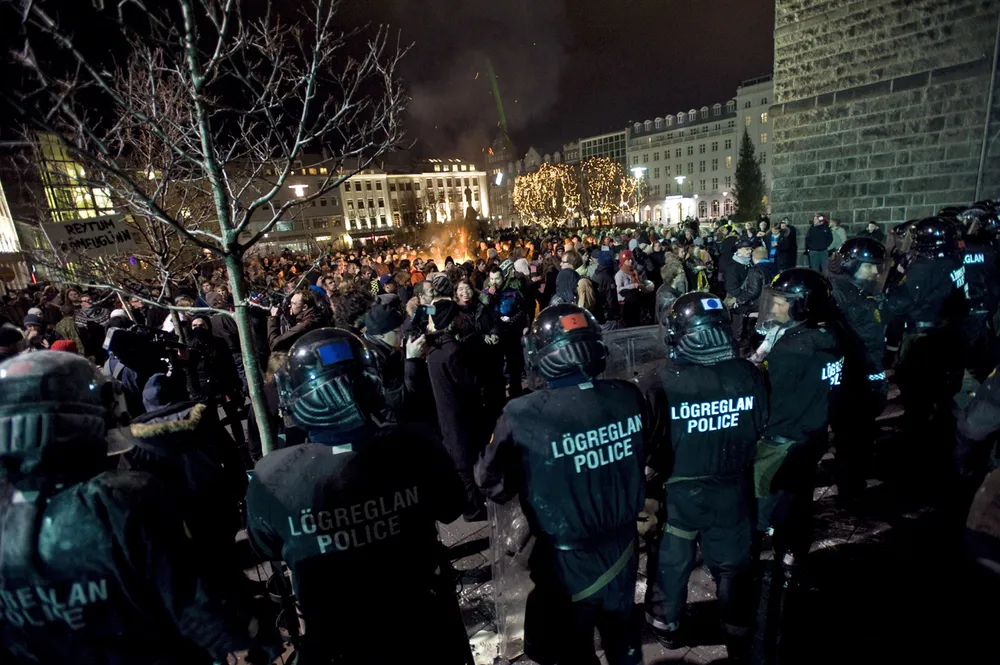 Stand-off: riot police stand face-to-face with about 2000 demonstrators outside the Althing in Reykjavik last night