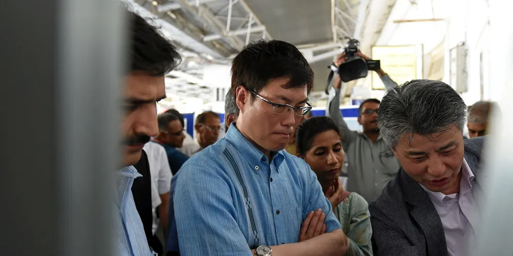 Masatoshi Akimoto (C) looks on during a visit to India.