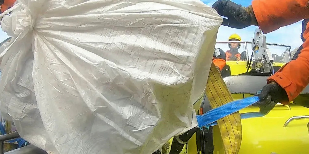 Mannskap på KV «Jarl» bidrar i opprydning. Dette er avfall som er ryddet under årets ryddeaksjon og hvor Kystvakten og de vernepliktige mannskapene bidro med å transport.