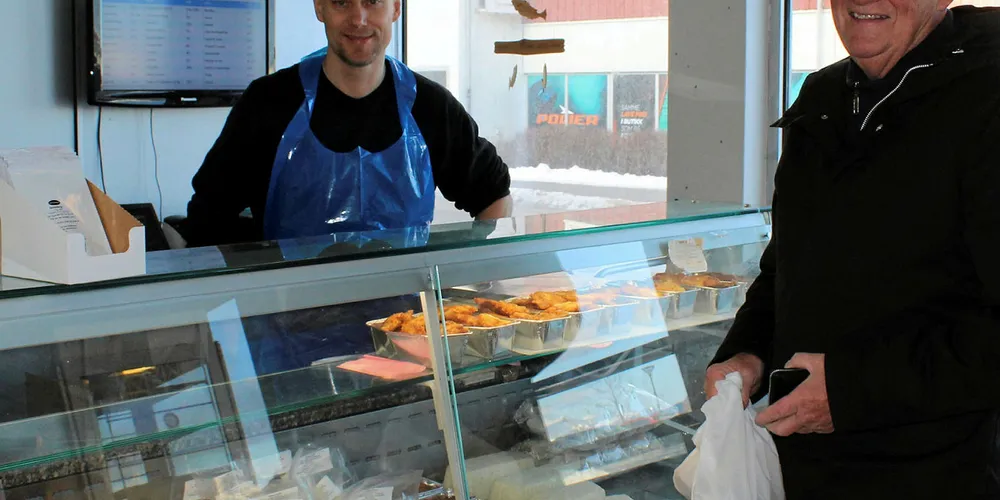 STAMKUNDE: – Fiskebutikken er veldig viktig for oss i Sandnessjøen, sier stamkunde Skule Storheil. John Ivar Værnes har drevet fiskeforretningen i sentrum av helgelandsbyen siden 2000, og trives godt som leverandør av sjømat til helgelendingene.