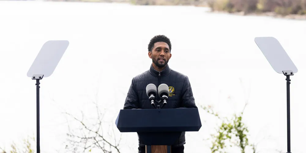 Baltimore mayor Brandon Scott speaks on the collapse of the Francis Scott Key Bridge, pictured in the background, during a visit from US President Joe Biden.