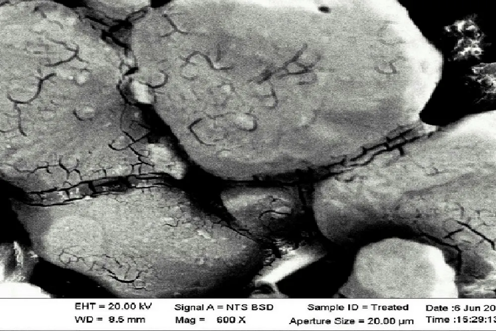 Up close: A micrograph shows sand treated with self-assembling nanoparticles and resulting available pore space.