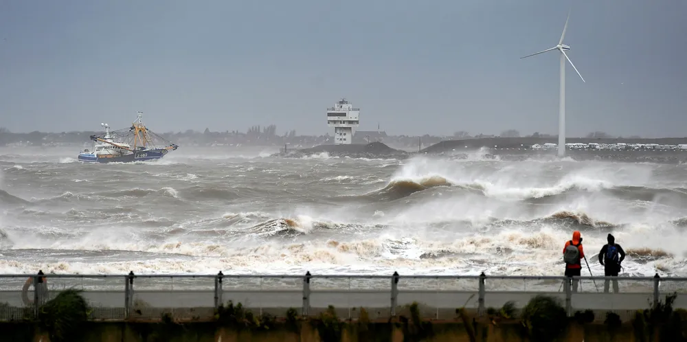 People watch as a fishing boat navigates stormy seas on its way into the River Mersey, in New Brighton, north west England, on February 9, 2020, as Storm Ciara swept over the country.