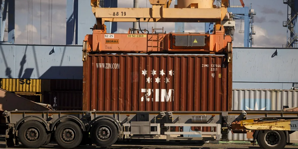 A crane Lifts a Zim branded shipping container at the Port of Haifa.