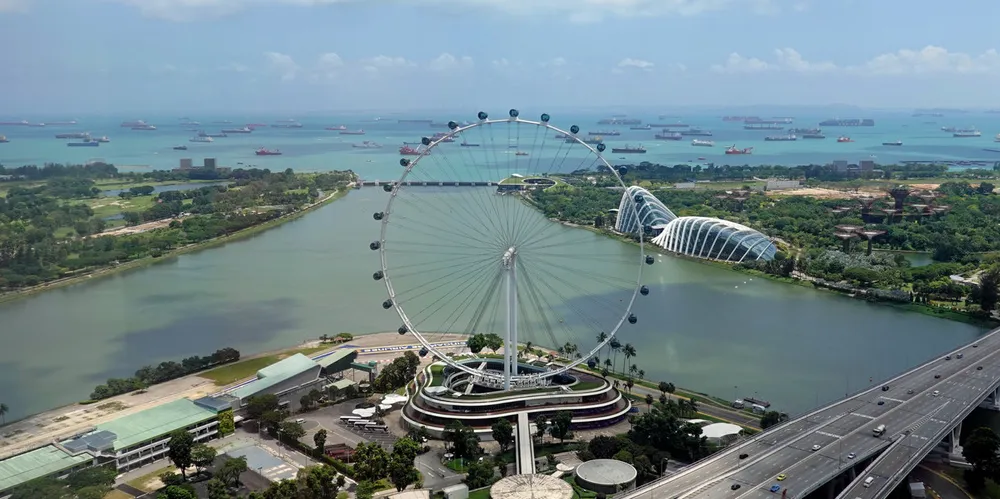 Ships at anchor off Singapore with the Singapore Strait in the background.