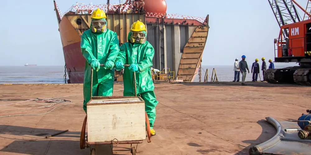 Workers transporting hazardous materials at a Hong Kong Convention-certified yard in India.