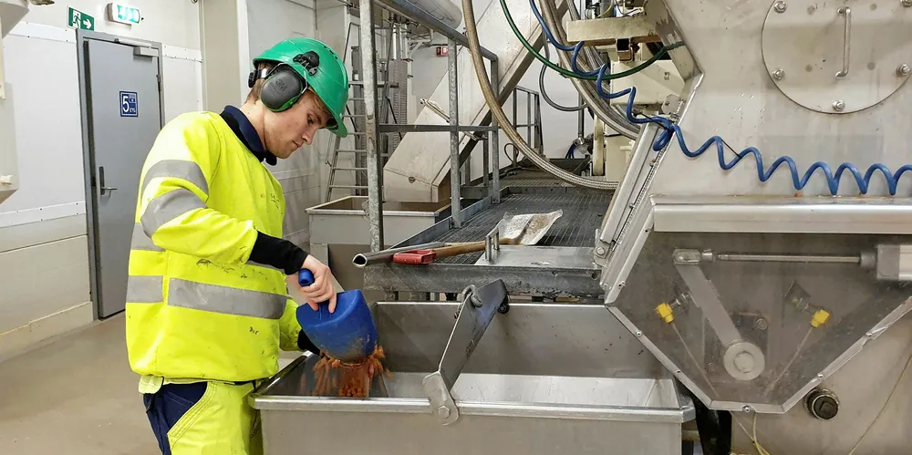 En operatør tar prøver av Skretting sitt fôr ved fabrikken på Averøy i Møre og Romsdal.