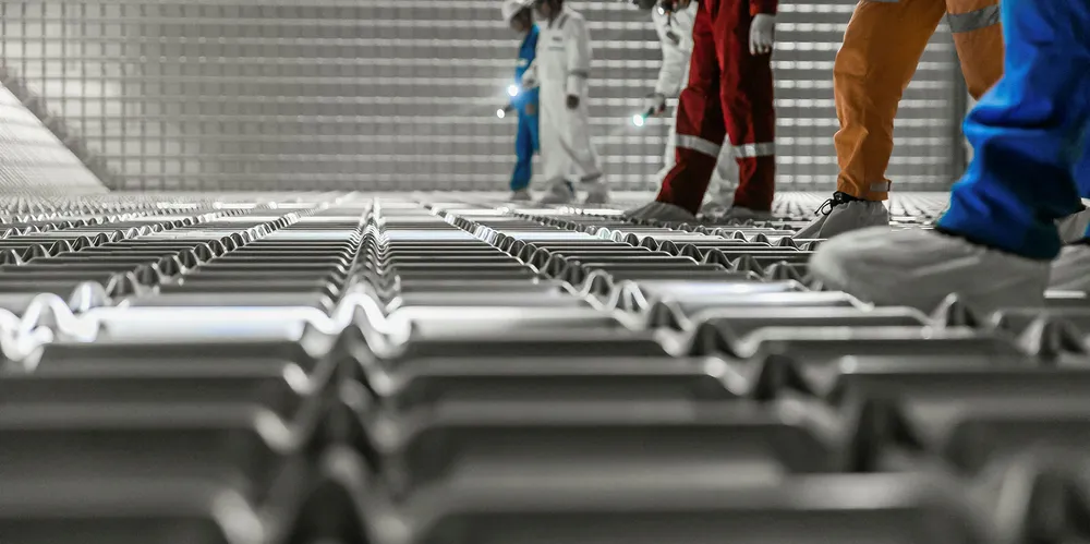 Workers inspect a GTT containment system.