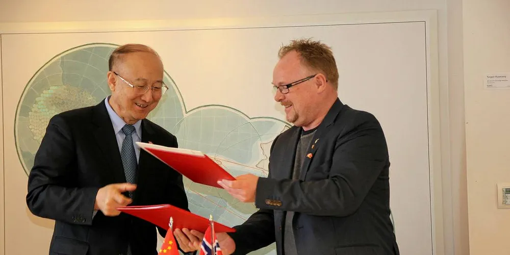 ENIGE: Fiskeriminister Per Sandberg signerer avtale med Zhi Shuping, ministeren for Kinas veterinærmyndigheter (AQSIQ). Pressefoto