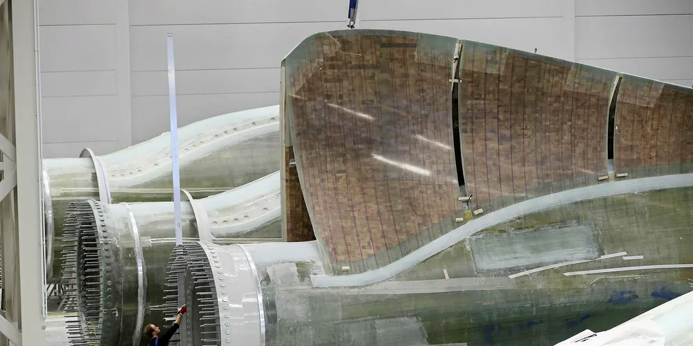 A worker prepares rotor blades for wind turbines at an Enercon factory in Germany.