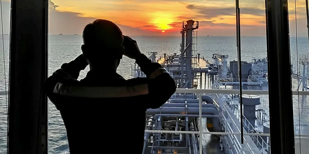 An officer keeps watch on an LNG carrier while transiting the Singapore Strait.