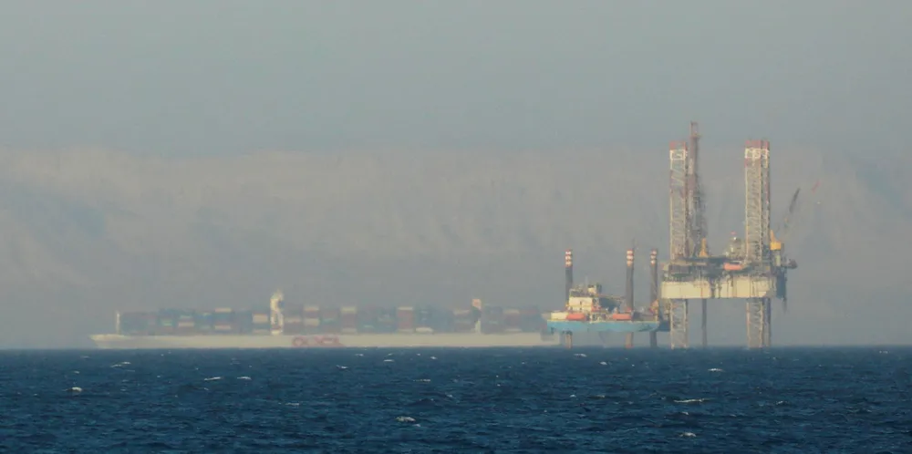 A container ship crosses an oil platform at the Gulf of Suez towards the Red Sea before entering the Suez Canal in 2020.