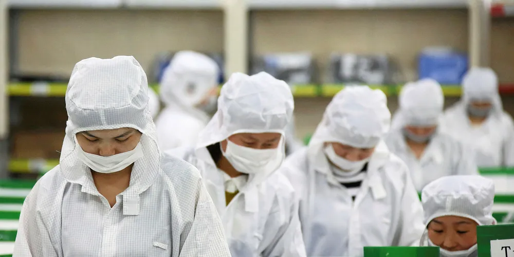Employees perform final inspections on solar cells on the production line at the Trina Solar factory in Changzhou, China.