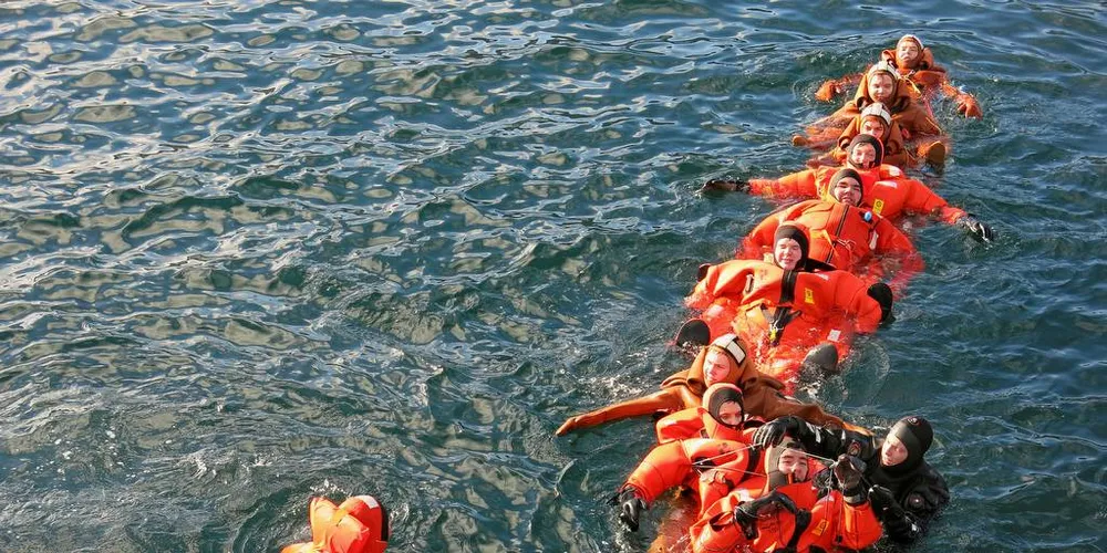 PÅ SIKKERHETSKURS: Ni elver på linjen maritime fag ved Nordkapp maritime fagskole holder fast i hverandre. Her sammen med to instruktører. De er en del av en gruppe på 17 som i begynnelsen av september gikk på det grunnleggende sikkerhetskurset for fiskere.Foto: Agnar Berg